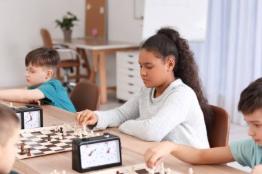 Kulüpte turnuvada satranç oynayan küçük çocuklar.