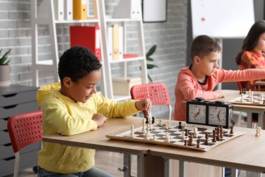 Kulüpte turnuvada satranç oynayan küçük çocuklar.
