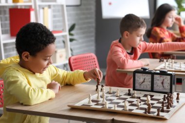 Kulüpte turnuvada satranç oynayan küçük çocuklar.