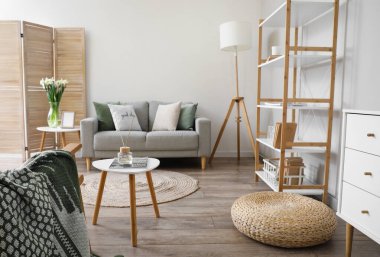 İçinde kanepe, masa ve raf ünitesi olan bir oturma odası.