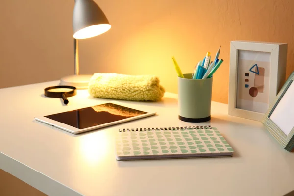 Komputer Typu Tablet Materiały Piśmienne Świecąca Lampa Stole Pobliżu Ściany — Zdjęcie stockowe