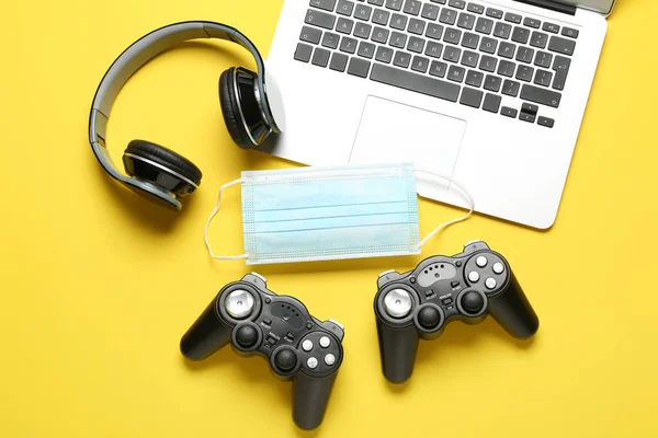 Moderne Laptop Hoofdtelefoon Gamepads Medisch Masker Kleur Achtergrond — Stockfoto