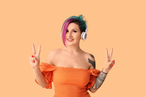 Красивая Женщина Необычными Волосами Татуировкой Слушает Музыку Оранжевом Фоне — стоковое фото
