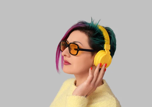 Hermosa Mujer Con Cabello Inusual Escuchando Música Sobre Fondo Gris — Foto de Stock