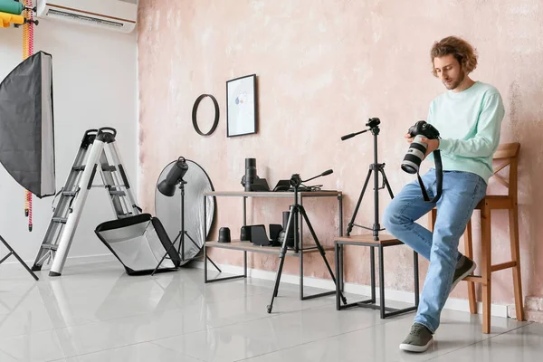 Fotógrafo Masculino Com Câmera Sentada Cadeira Perto Parede Rosa Estúdio — Fotografia de Stock