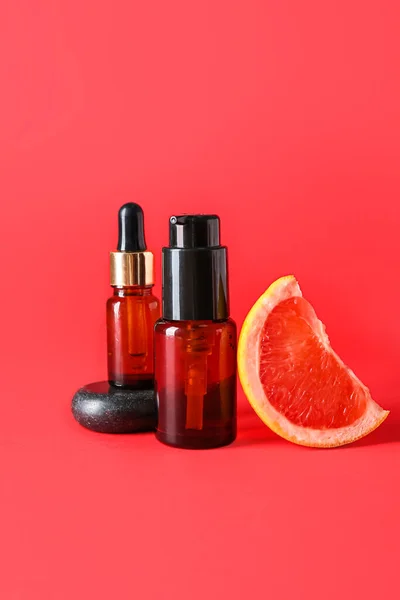 Bottles Essential Oil Piece Grapefruit Red Background — Stock Photo, Image