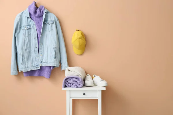 Renkli Duvarın Yanındaki Masada Şık Kıyafetler Ayakkabılar — Stok fotoğraf