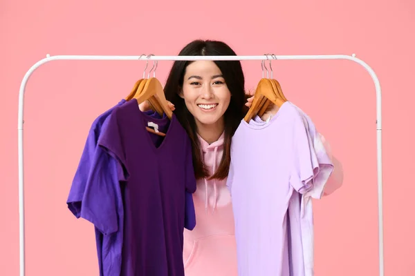 Ung Asiatisk Kvinna Och Rack Med Shirts Rosa Bakgrund — Stockfoto
