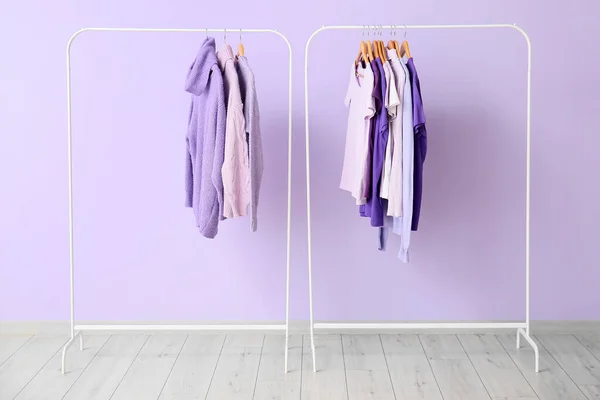 Racks Avec Des Vêtements Dans Les Tons Violets Près Mur — Photo