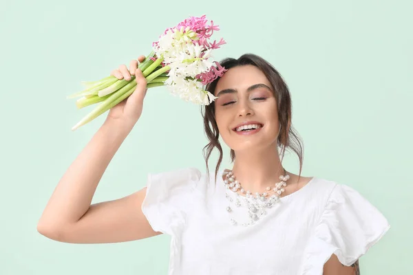 Yeşil Arka Planda Sümbül Çiçekleri Olan Güzel Genç Bir Kadın — Stok fotoğraf