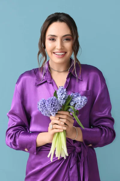青い背景にヒヤシンスの花を持つかなり若い女性 — ストック写真