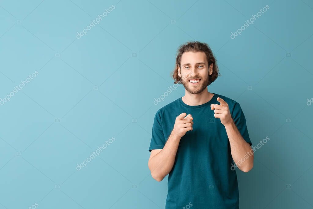 Handsome young man in stylish t-shirt on blue background