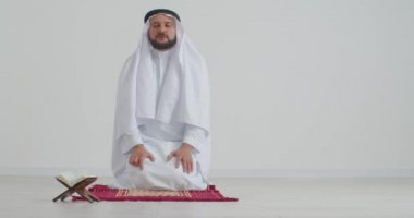 Müslüman adam aydınlık odada Allah 'a dua ediyor.