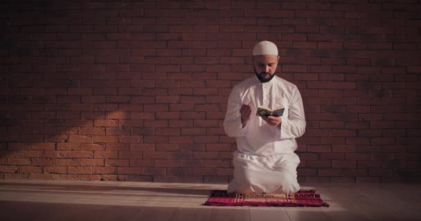 Hombre Musulmán Leyendo Corán Cerca Pared Ladrillo — Vídeos de Stock