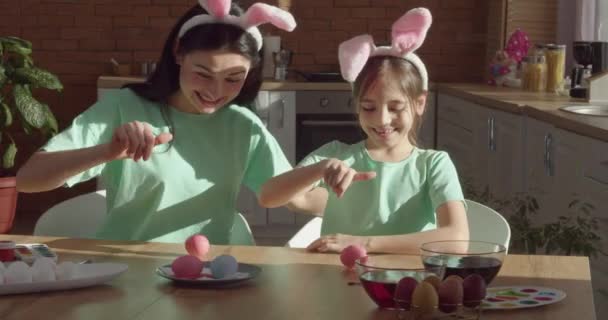 Mother Little Daughter Bunny Ears Spinning Easter Eggs Kitchen Table Stock Video