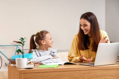 Evde öğretmenle ders çalışan tatlı bir kız.