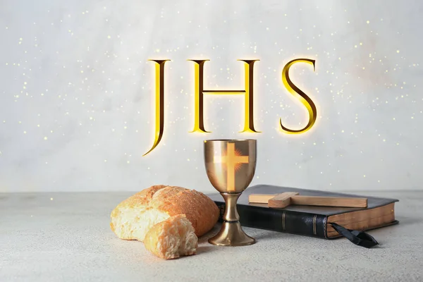 Chalice of wine with bread, Bible and cross on light background. Holy Communion concept