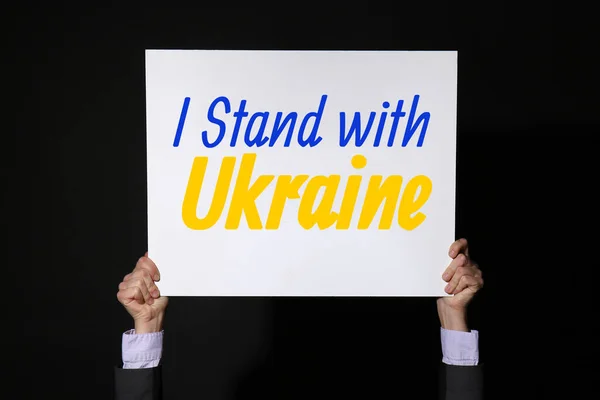 Mãos Segurando Cartaz Com Texto Stand Com Ucrânia Fundo Preto — Fotografia de Stock
