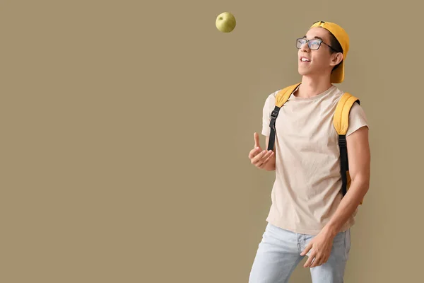 Männlich Asiatischen Studenten Werfen Apfel Auf Farbe Hintergrund — Stockfoto