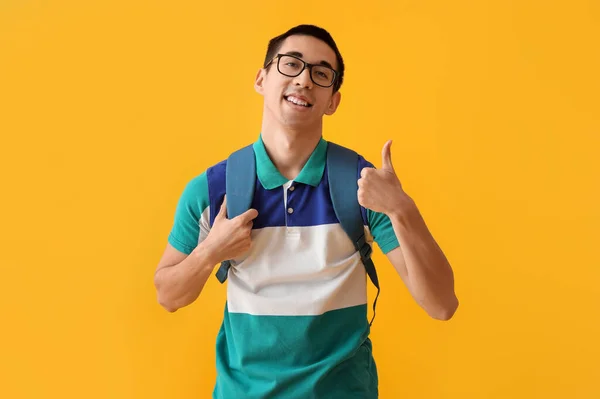 Gözlüklü Asyalı Erkek Öğrenci Sarı Arka Planda Baş Parmak Gösteriyor — Stok fotoğraf