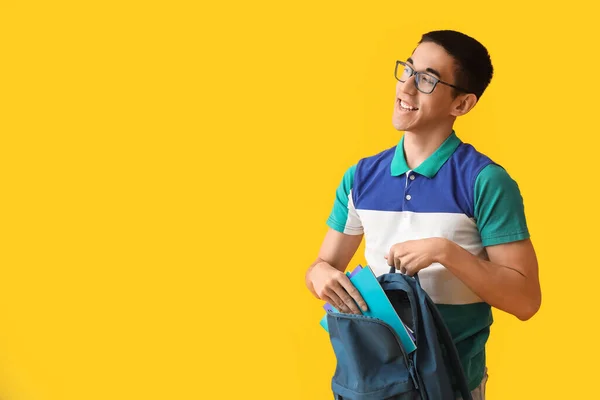 Männlich Asiatisch Student Put Copybooks Rucksack Auf Gelb Hintergrund — Stockfoto