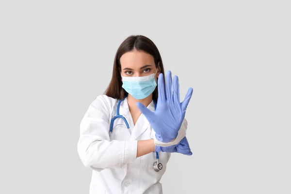 Ung Kvinnlig Läkare Medicinsk Mask Visar Stopp Gest Ljus Bakgrund — Stockfoto