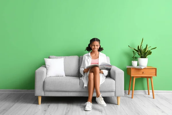 African American Teenage Girl Reading Magazine While Sitting Sofa Home — Stock Photo, Image