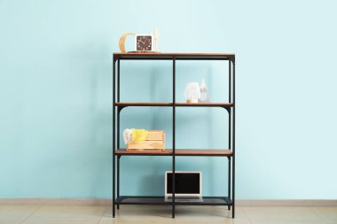 Renk duvarının yanında dekor ve modern dizüstü bilgisayarı olan raf ünitesi duruyor.