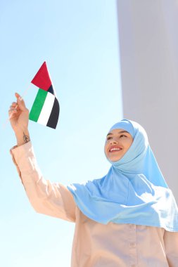 Açık havada BAE bayrağı taşıyan güzel Müslüman kadın.