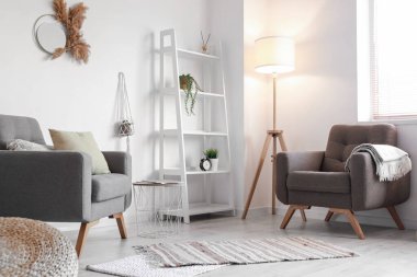 Rahat koltukları ve raf ünitesi olan modern oturma odasının içinde.
