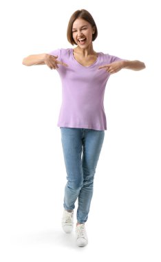 Beyaz arka planda şık tişörtlü mutlu genç kadın.