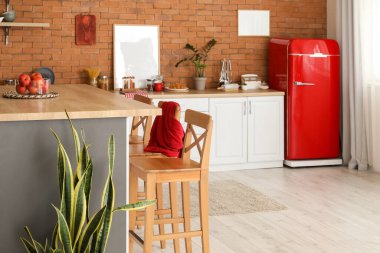 Modern mutfak, yemek masası, tezgah ve şık buzdolabı.