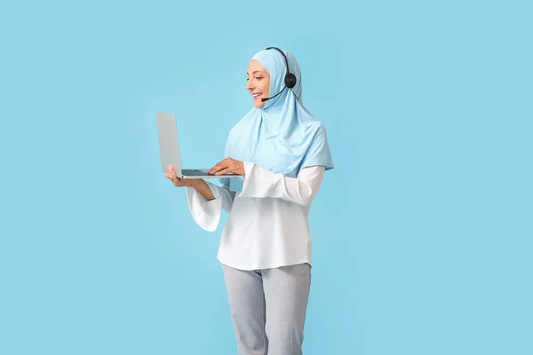 带着耳机和彩色背景笔记本电脑的穆斯林秘书 — 图库照片