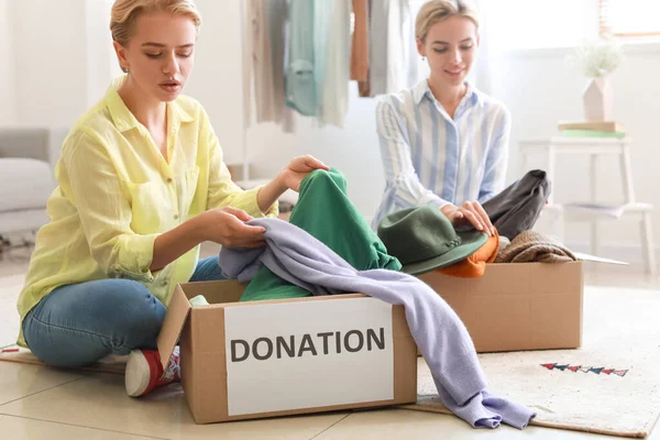 Giovani Donne Che Mettono Vestiti Scatole Donazione Casa — Foto Stock