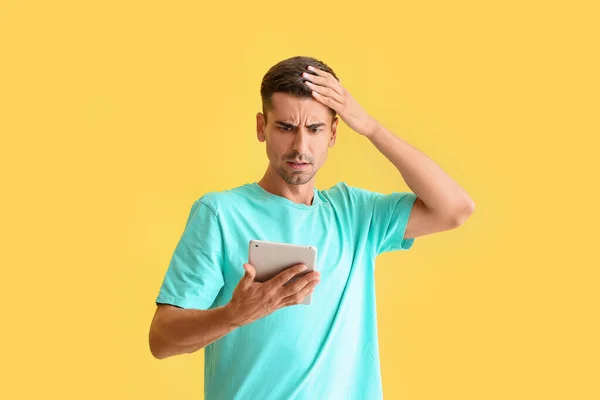 Hombre Joven Preocupado Con Tableta Fondo Color —  Fotos de Stock
