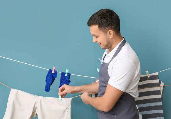 Joven Colgando Ropa Limpia Con Pinza Ropa Sobre Fondo Azul — Foto de Stock