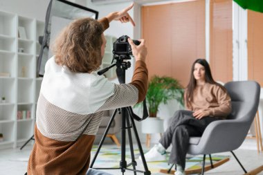 Modern stüdyoda kadın modelle çalışan fotoğrafçı.