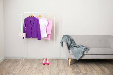 Elbiselerle, topuklularla ve ışıklı duvarın yanındaki kanepeyle dizilin.