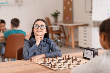 Kulüpte turnuvada satranç oynayan küçük çocuklar.
