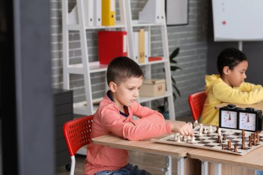 Kulüpte turnuvada satranç oynayan küçük çocuklar.