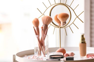 Masada farklı kozmetik ürünler ve makyaj fırçaları