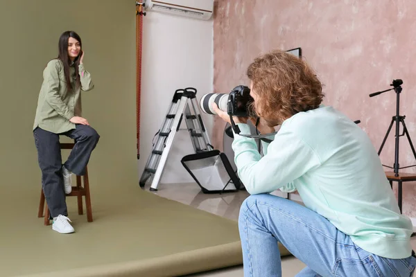 Stüdyoda kadın modelin fotoğrafını çeken fotoğrafçı.