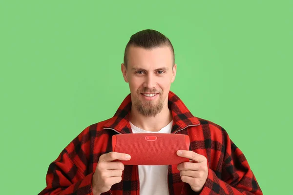 Mladý Usměvavý Muž Drží Bezdrátový Přenosný Reproduktor Zeleném Pozadí — Stock fotografie