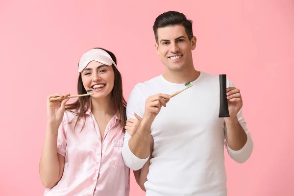 Junges Paar Beim Zähneputzen Mit Aktivkohle Zahnpasta Auf Rosa Hintergrund — Stockfoto
