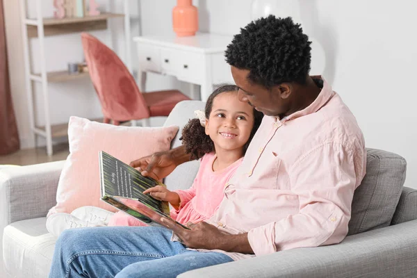 快乐的非裔美国人和他的小女儿在家里看书 — 图库照片
