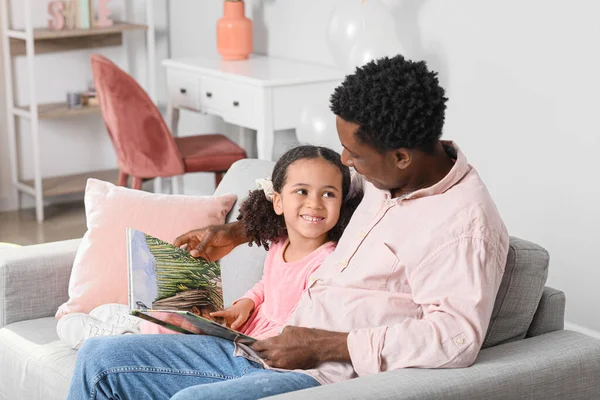 快乐的非裔美国人和他的小女儿在家里看书 — 图库照片