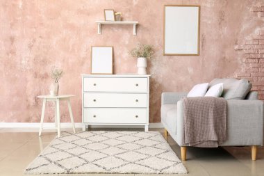 Vazo ve jigolo çiçekleri ve oturma odasındaki çekmecelerin üzerindeki çerçeve.