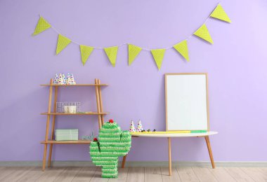 Doğum günü partisi için dekore edilmiş masa, raf ünitesi ve Meksika pinyatası olan şık bir oda.