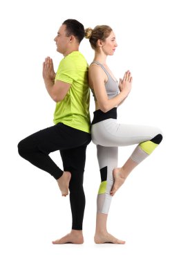 Beyaz arka planda yoga yapan sportif çift.