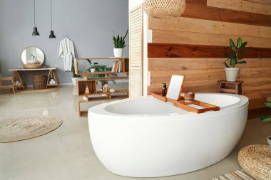 Beyaz küvetli ve çiçekli modern banyo.